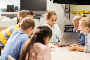 happy children with laptop at robotics school