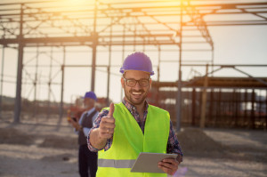 Engineer with thumb up on building site