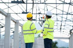 Construction manager and architect working on building site.